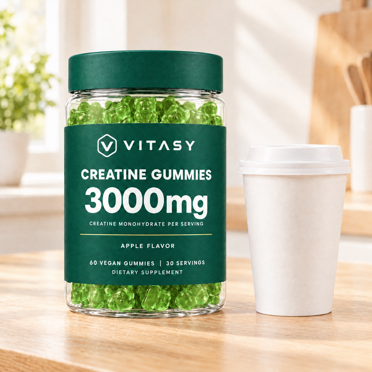 Apple Vitasy Creatine Gummies jar next to a coffee cup on a kitchen counter