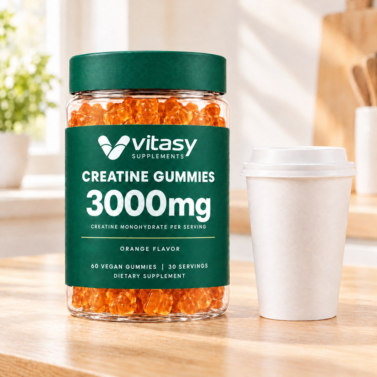 Orange Vitasy Creatine Gummies jar next to a coffee cup on a kitchen counter
