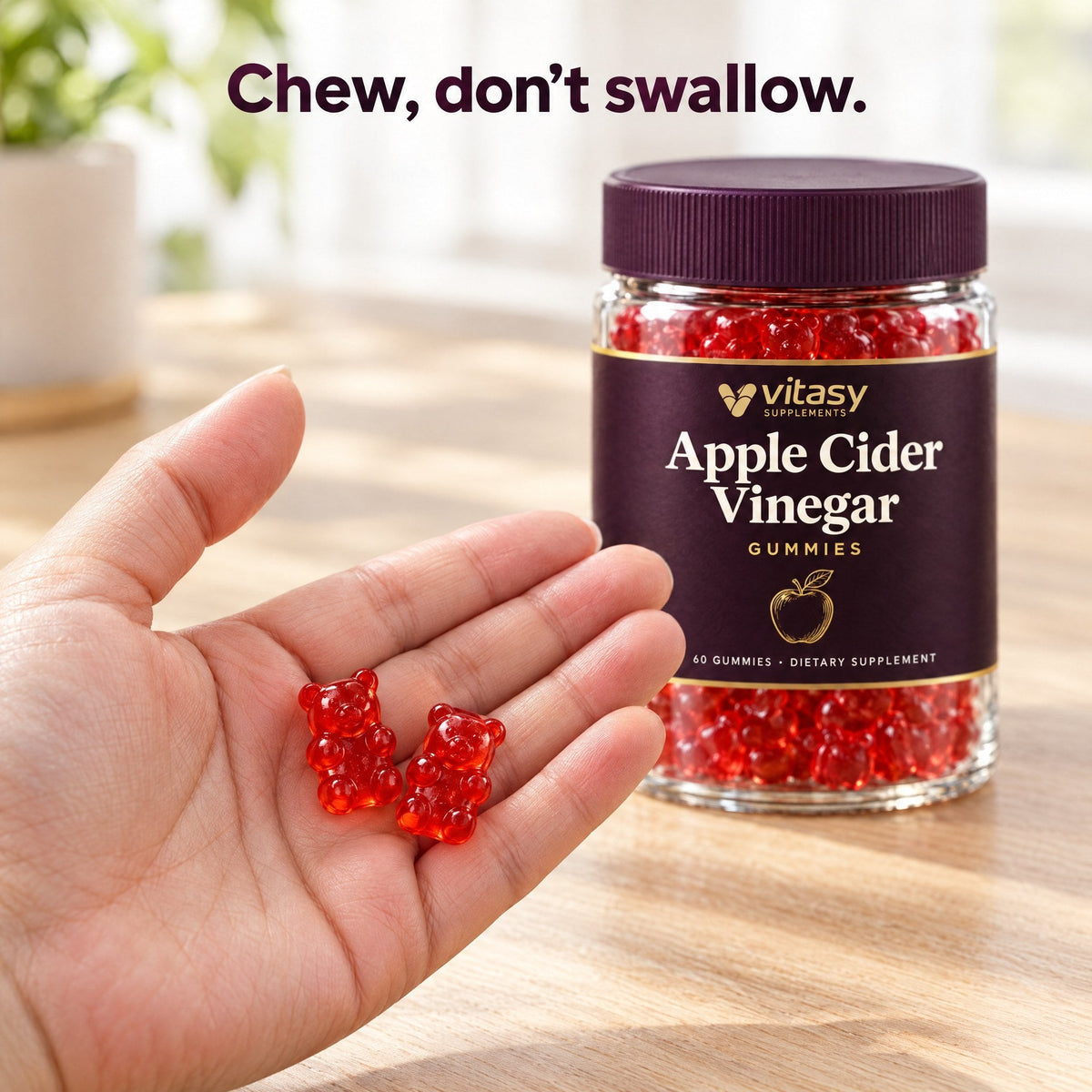 Two red Vitasy ACV gummy bears in an open hand
