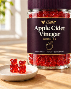 Two red Vitasy apple cider vinegar gummy bears next to the jar