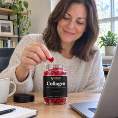 Woman at her desk taking a gummy from the Vitasy jar