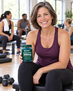 Woman on a gym bench after a weights class holding the Vitasy jar