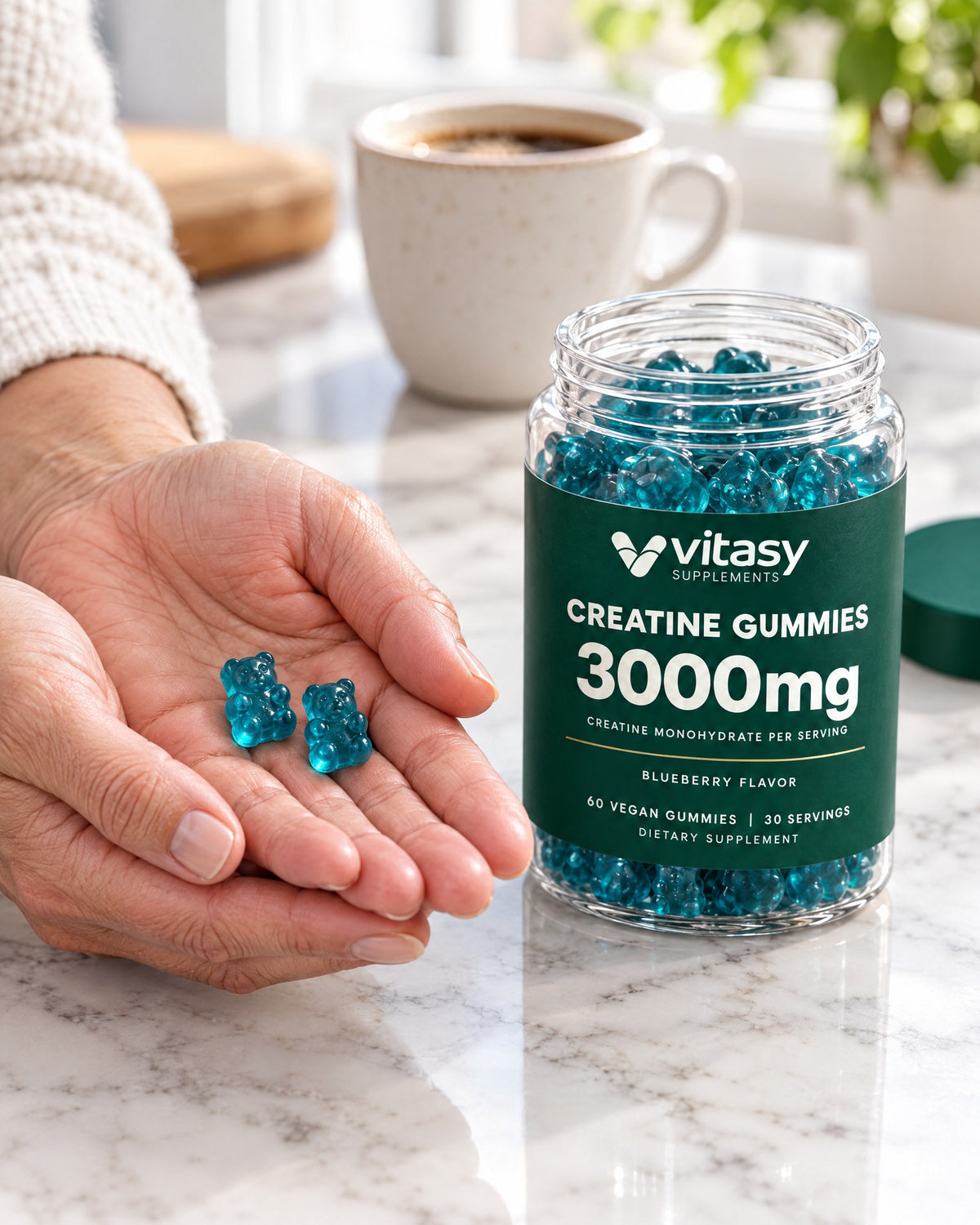 Two creatine gummies in a hand next to the Vitasy jar