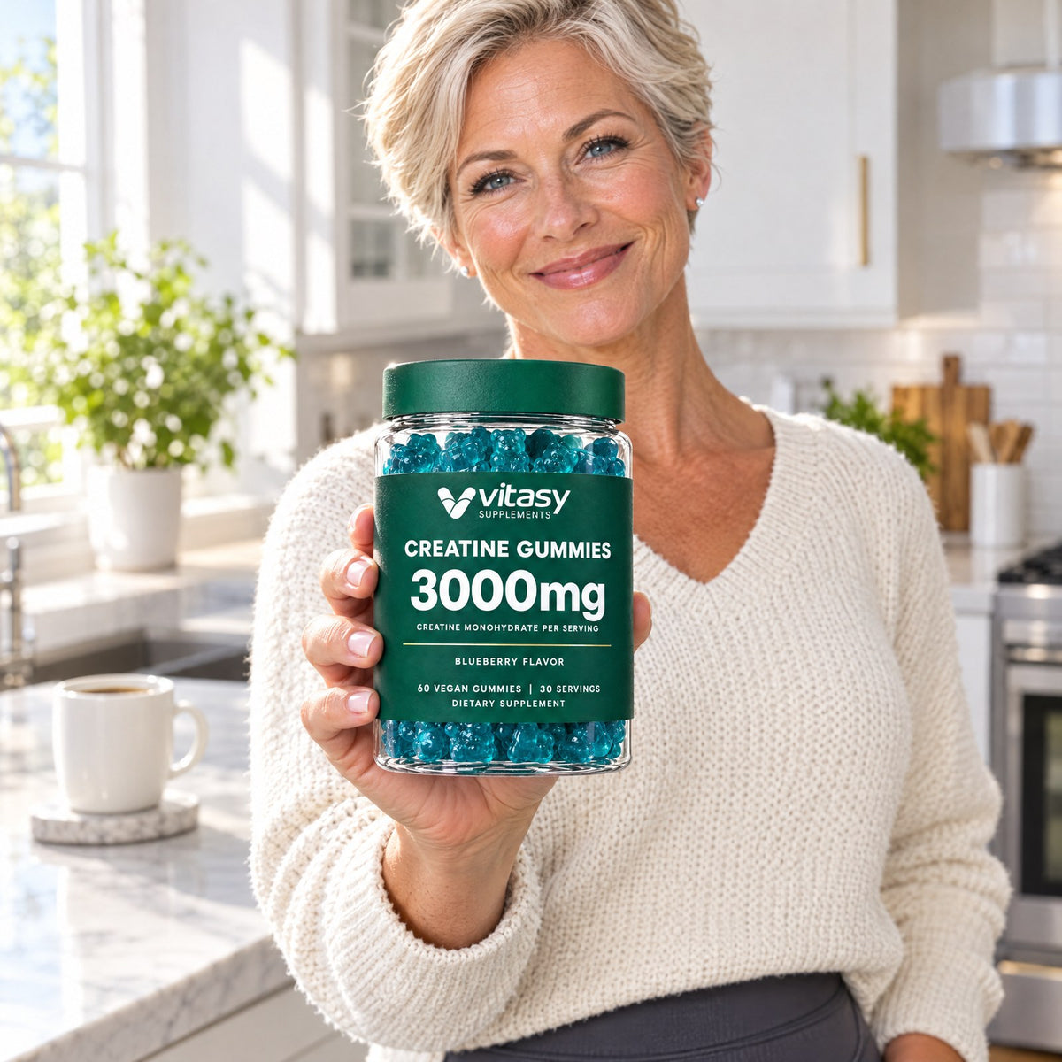 Woman in her kitchen holding the Vitasy Creatine Gummies jar