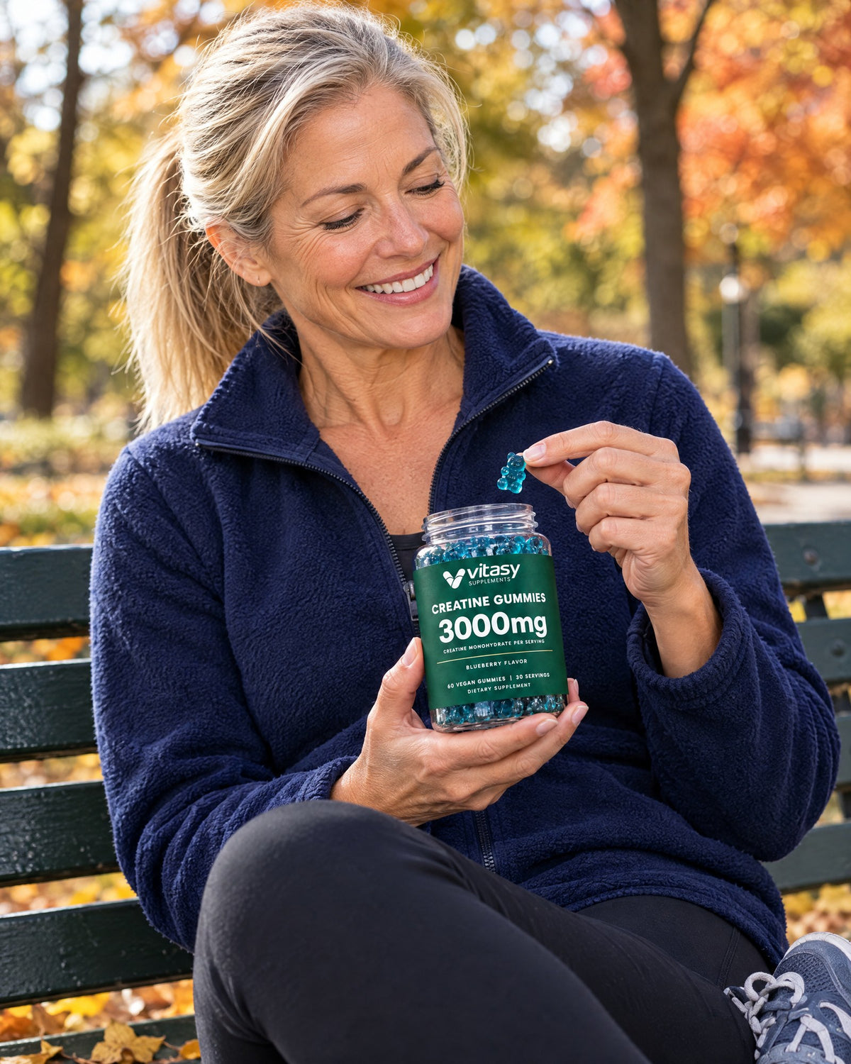 Woman on a park bench after a walk taking a Vitasy creatine gummy