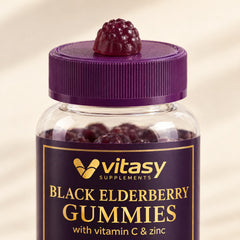 A dark purple Vitasy elderberry gummy on the jar lid