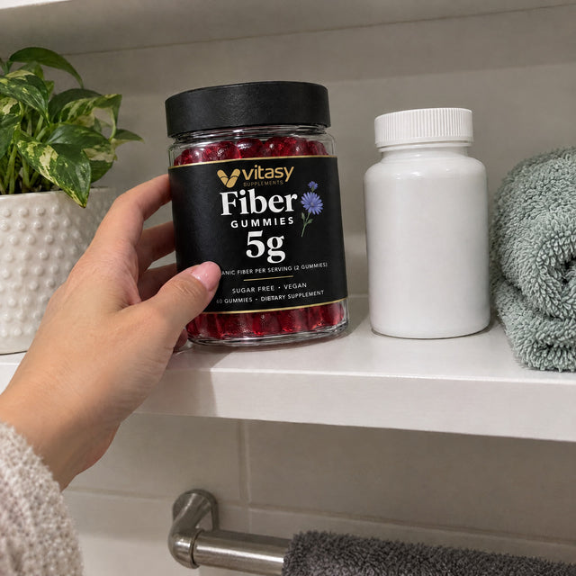 Hand setting the Vitasy jar on a shelf next to a vitamin bottle
