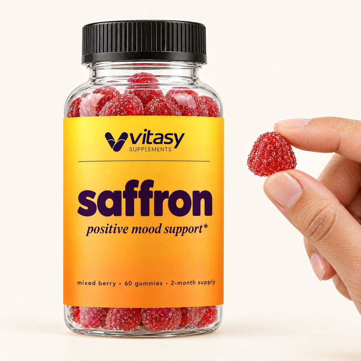 Vitasy Saffron Gummies bottle with one red gummy held between two fingers
