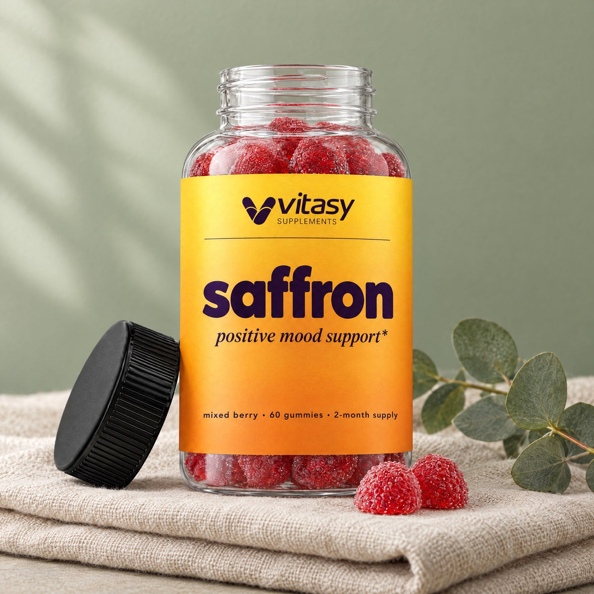 Vitasy saffron gummies bottle on linen with eucalyptus