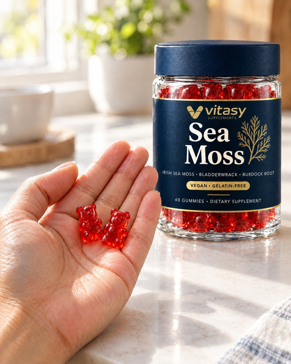 Two sea moss gummies in an open hand next to the Vitasy jar