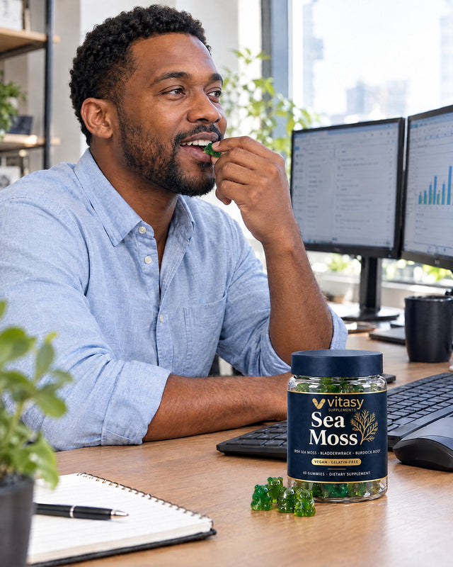 Man at his desk taking a gummy from the Vitasy jar