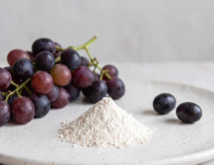 Dark grapes next to resveratrol powder