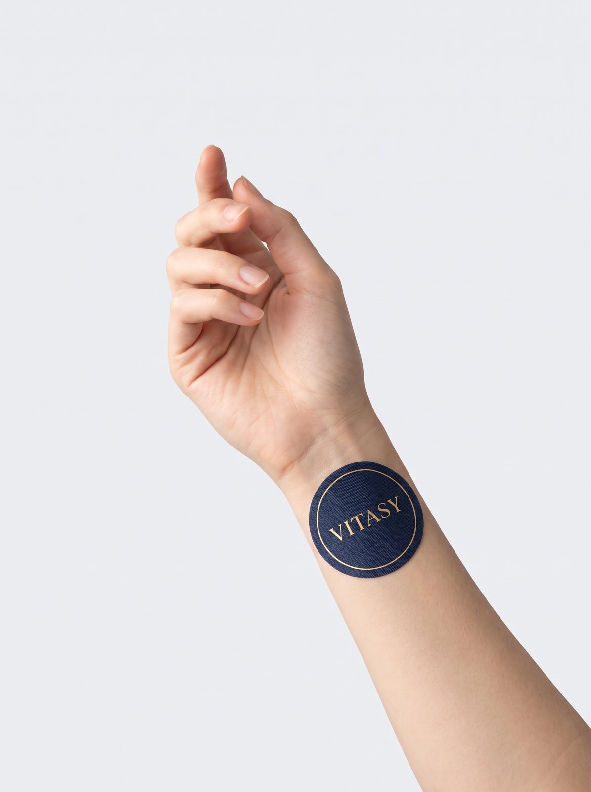 Hand with a navy Vitasy patch on the wrist