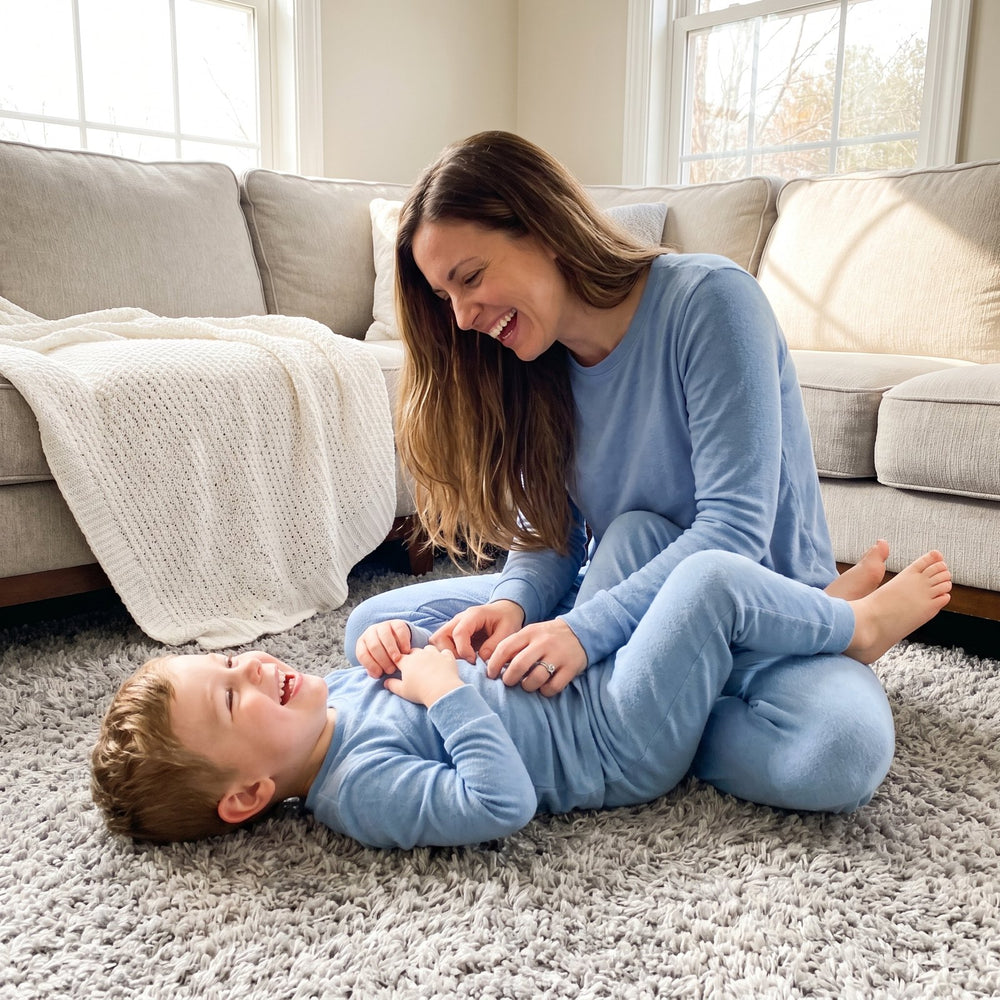 Mother and young son laughing together on a soft rug in a cozy living room