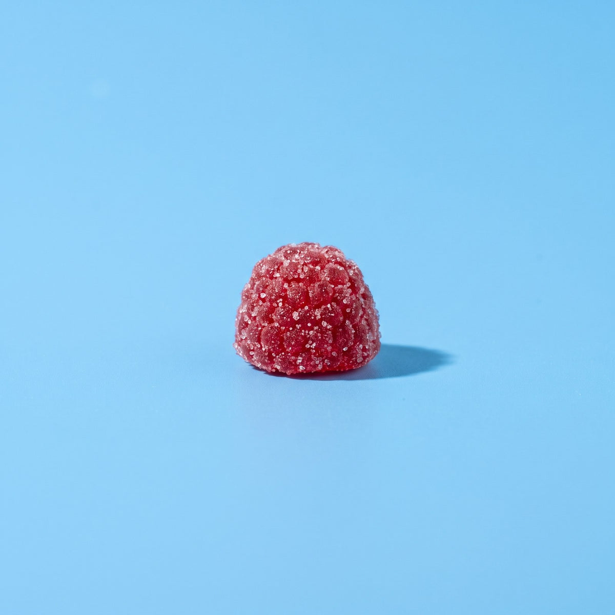 One mixed berry saffron gummy on a blue background