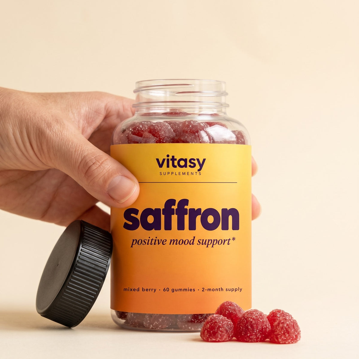 Parent's hand holding a bottle of Vitasy Saffron Gummies