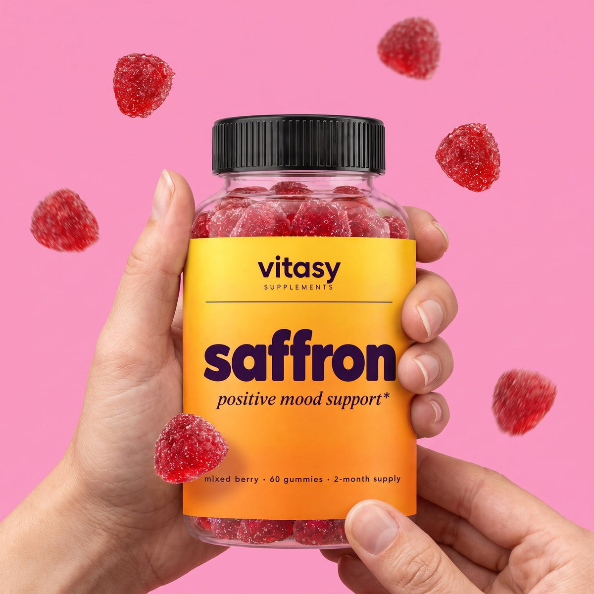 Parent's hands holding a jar of Vitasy Saffron Gummies on a pink background