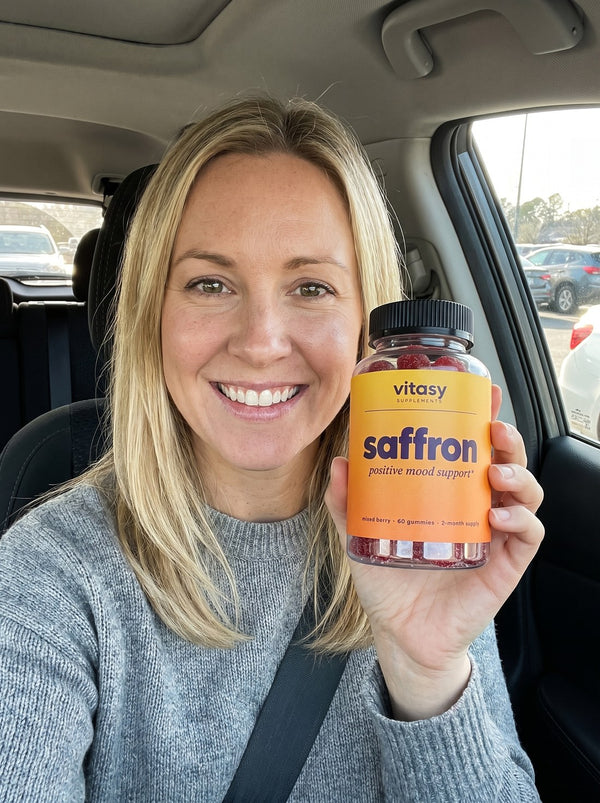 Mom holding a bottle of Vitasy Saffron Gummies in the car