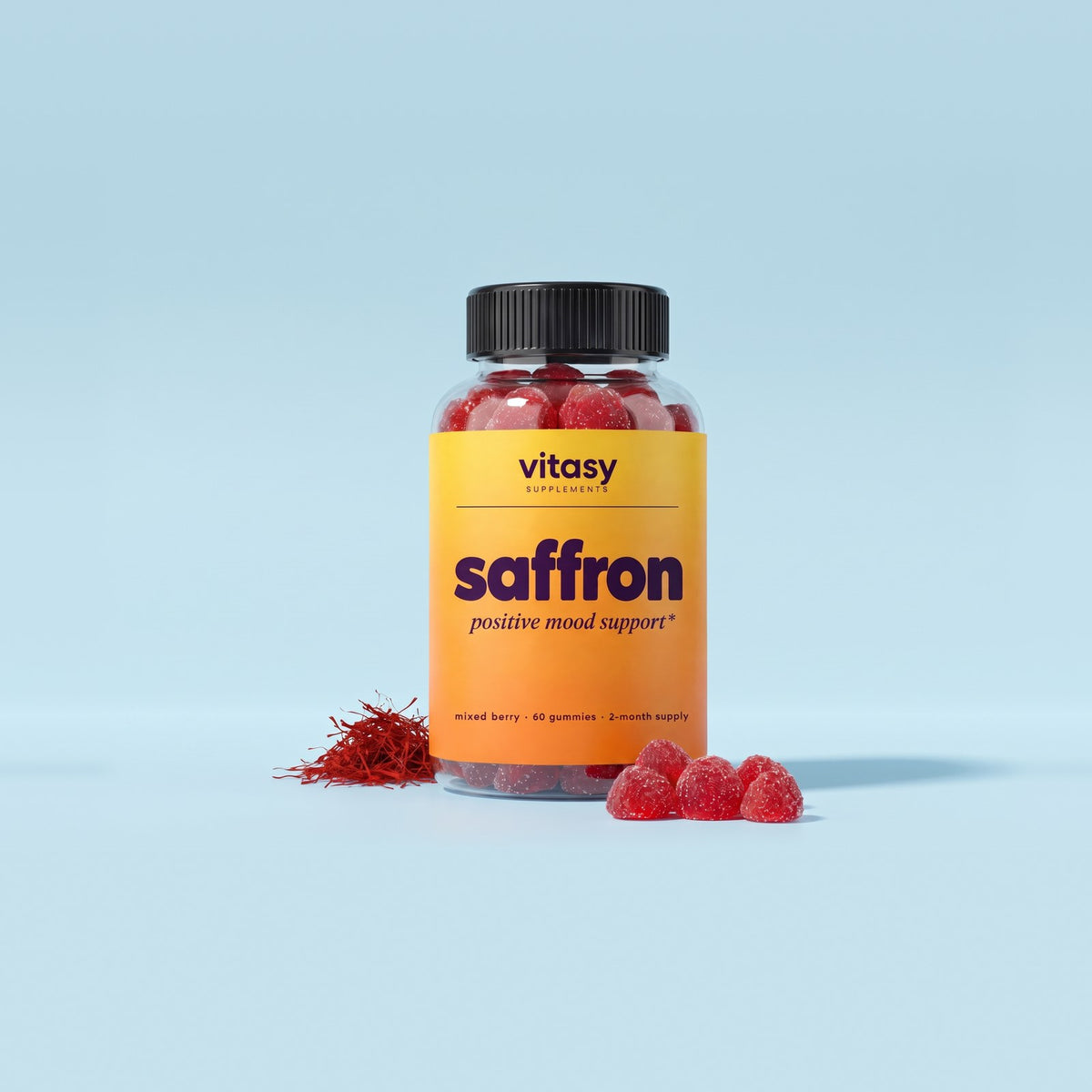 Vitasy Saffron Gummies jar on a light blue background next to saffron threads