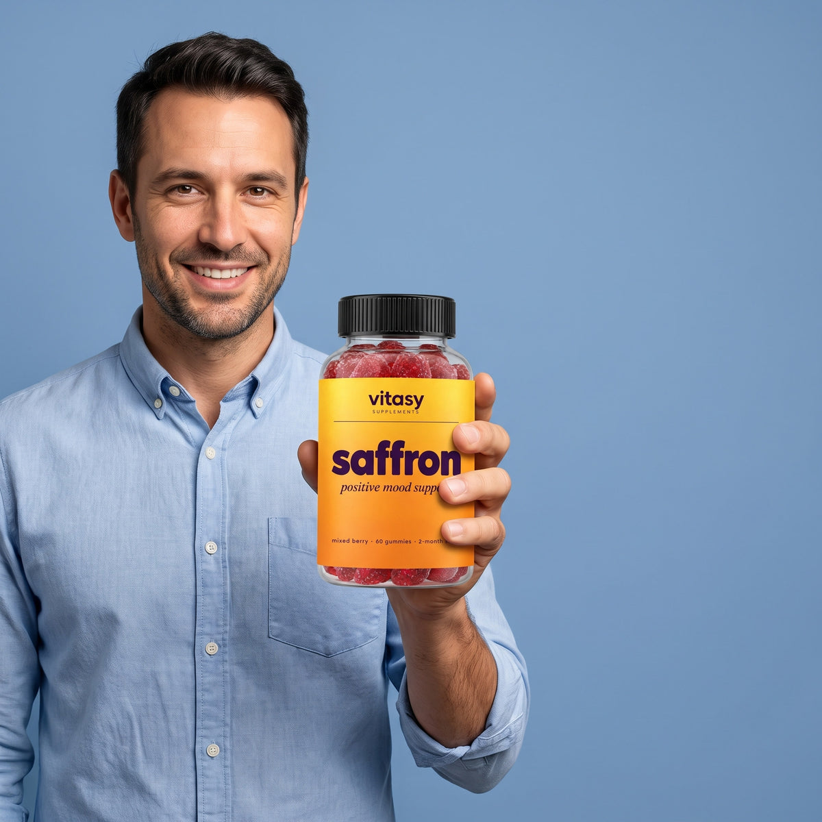 Smiling dad holding a bottle of Vitasy Saffron Gummies next to the Supplement Facts panel