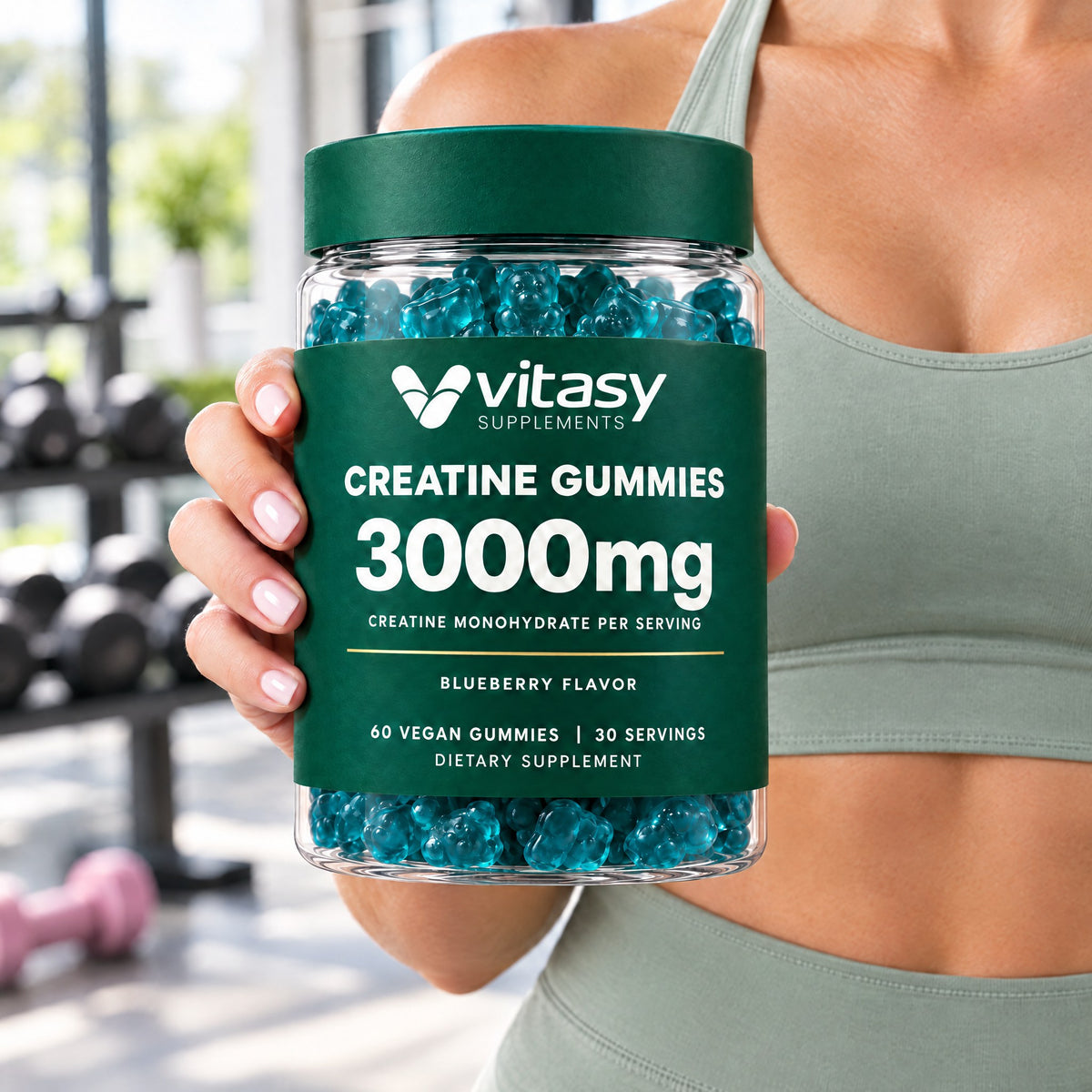Woman in a gym holding a jar of Vitasy Creatine Gummies