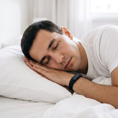 Man sleeping on his side in a white bed