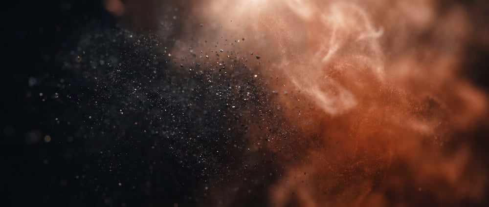 Macro of fine powder particles in charcoal and warm orange tones