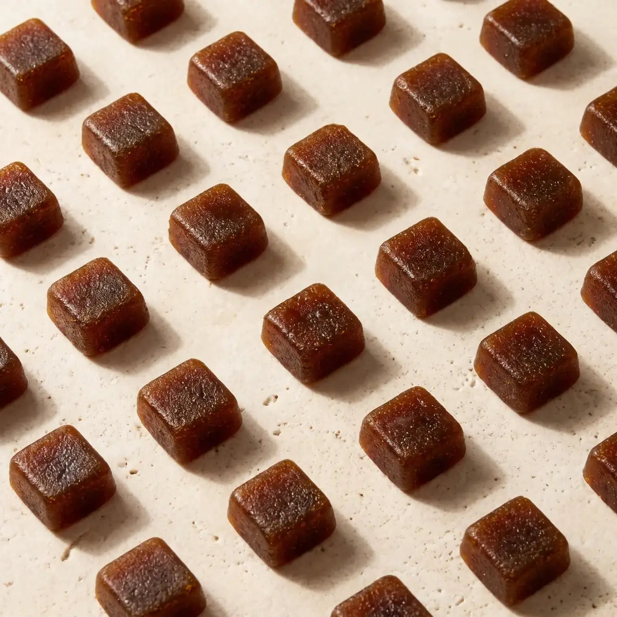 Amber gummies arranged on a warm stone surface